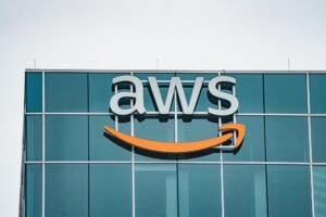 AWS logo with the Amazon smile on the glass facade of an office building
